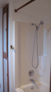 Inside bathroom shower-tub on right linen closet across from toilet